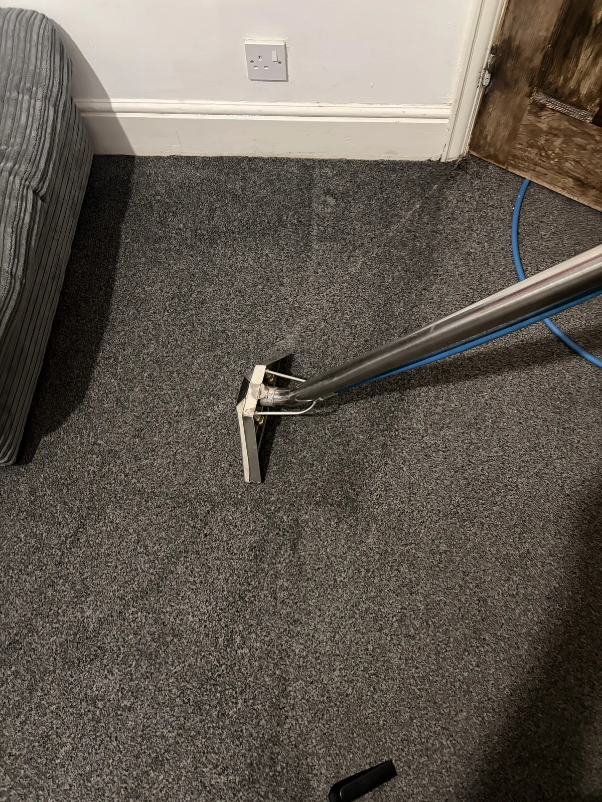 Home 12 Carpet cleaning wand on a grey carpet beside a sofa